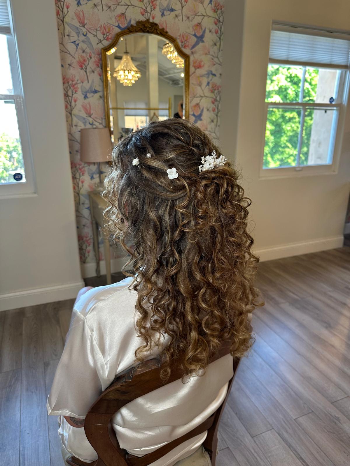 Classic bridal updo hairstyle with floral accessories by Makeup by Coyotzi